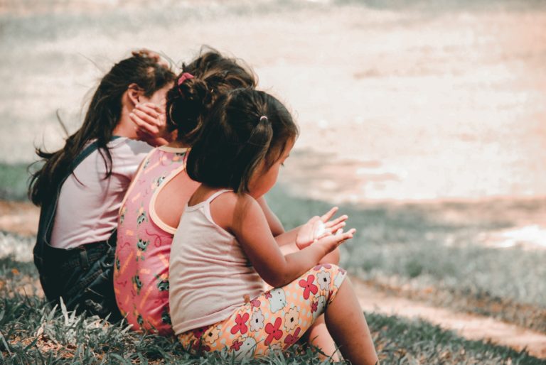 3 petites filles assisent dans l'herbe