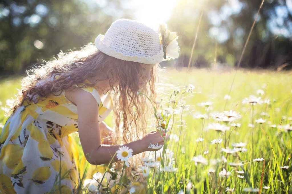 petite fille qui cueille des fleurs