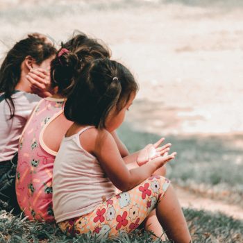 3 petites filles assisent dans l'herbe